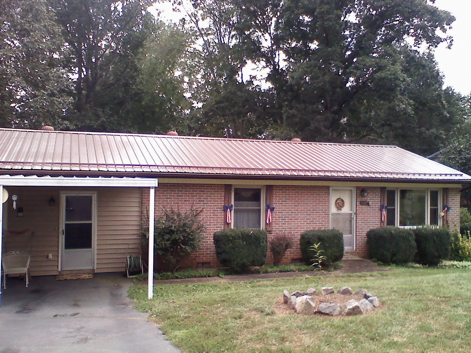 Bronze metal roof and carport on a brick ranch home — Roof Repair work by our crew in Oxford
